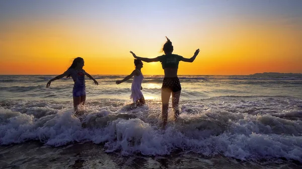 Mother Daughters Walking Jump Playing Beach Sunset Sprayed Ocean Waves — Stock Photo, Image