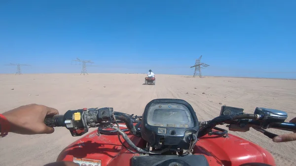 Quad bike ride through the desert near Sharm el Sheikh, Egypt.Adventures of desert off-road on ATV.Sand and Sand Borkhan. Rock and sunset. Quad Cycle Travel. Excursion with people.