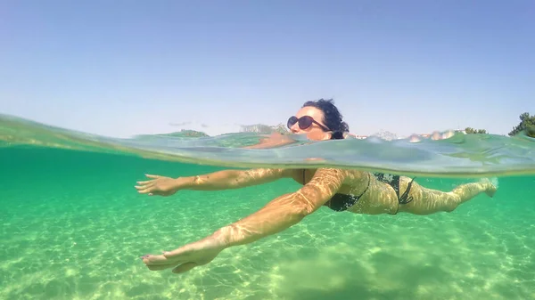 セクシーなファッションモデル女性水泳できれいな海ターコイズ水 Goproドーム半分水中トレッキングショット — ストック写真
