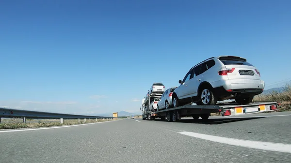 A large truck / car transporter delivers used cars driving on highway