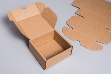 Brown cardboard box on grey background, opened, empty inside  clipart