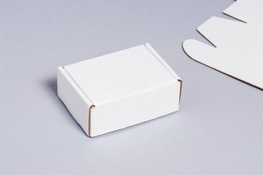 Gri arkaplanda beyaz karton kutu 