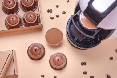 Kahve makinesinin kapsülünü mutfak masasına koymak.