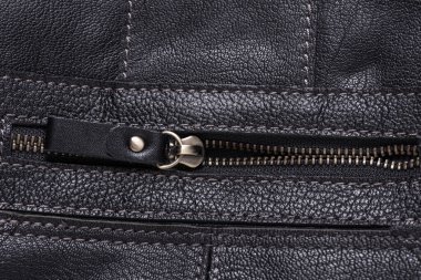 Metal fermuarlı siyah deri kaplama.