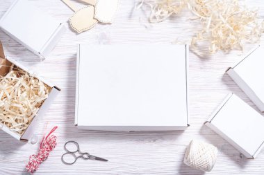 Tahta masadaki beyaz karton kutu, düz uzan. 