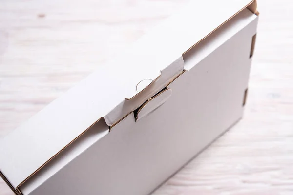 木製の机の上の白い段ボール箱 フラットレイモックアップ — ストック写真