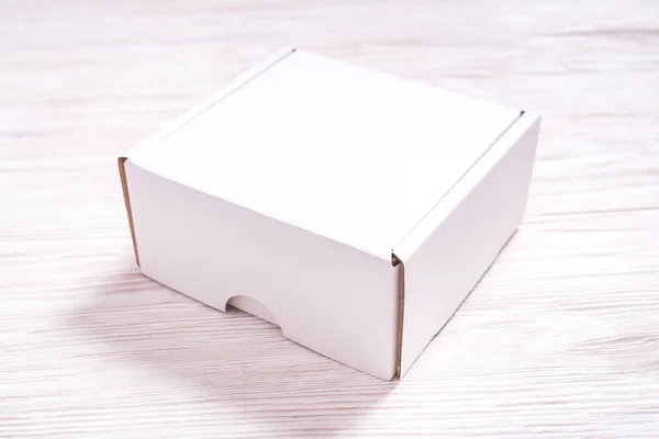 木製の机の上の白い段ボール箱 フラットレイモックアップ — ストック写真