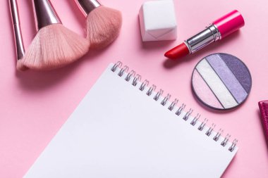 Kağıt defter düz yatıyordu pembe kozmetik masa üzerinde makara
