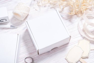 Tahta masadaki beyaz karton kutu, düz uzan. 