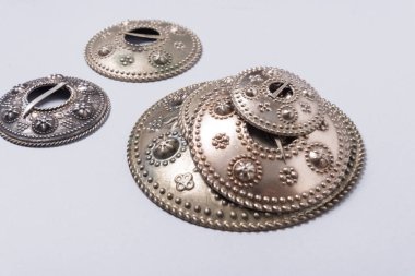 Bir sürü gümüş tonlu metal halk, milli broşlar, mücevherler.