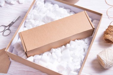 Bir sürü gevşek beyaz dolgu malzemesi karton içinde fıstık paketliyor. 