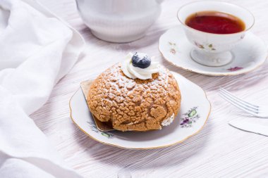 Tahta sırtında taze böğürtlenlerle süslenmiş bir parça çilekli pasta.