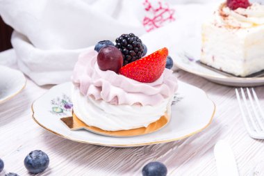 Tahta sırtında taze böğürtlenlerle süslenmiş bir parça çilekli pasta.