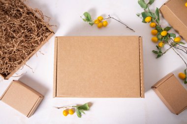 Taze yeşil yapraklı kahverengi karton kutu.