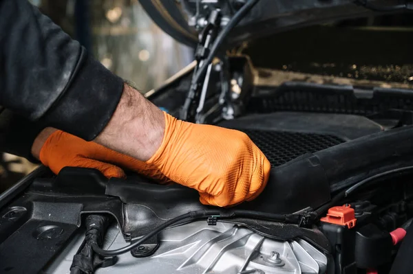 Mecánico de automóviles de trabajo y reparación en el motor del coche en el garaje mecánico. Servicio de coches. — Foto de Stock