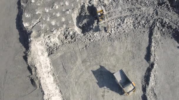 Bagr nakládá minerály na žlutý velký skládkový náklaďák. Otevřený důlní průmysl Top Aerial View. — Stock video