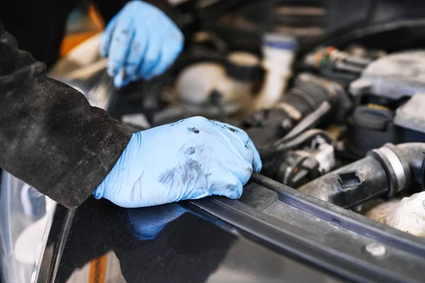 Mecánico de trabajo y reparación de motor de coche en el garaje mecánico. Servicio de coches. — Foto de Stock