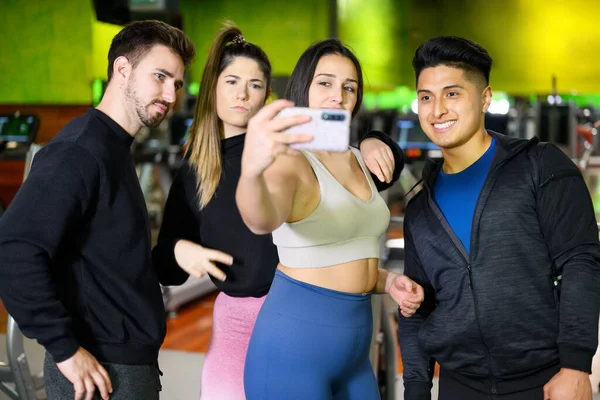 Happy friends with smartphone taking selfie in gym — Stock Photo, Image