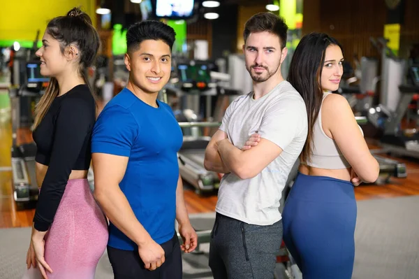 Groep van jonge atletische vrouwelijke en mannelijke volwassenen staan samen als goede vrienden in de sportschool na training sessie — Stockfoto