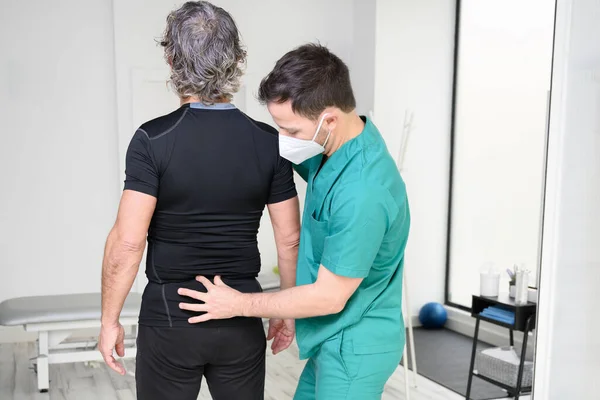 Vista posteriore di un fisioterapista che esamina l'uomo indietro. — Foto Stock