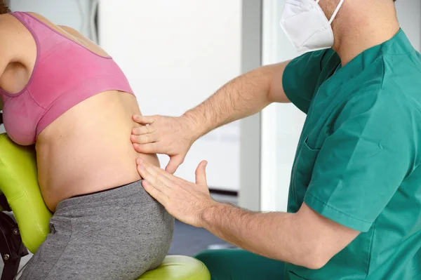 在温泉中心为孕妇做按摩的理疗师. — 图库照片