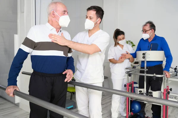 Gruppo di fisioterapisti che lavorano nel centro di riabilitazione, aiutando i pazienti. — Foto Stock