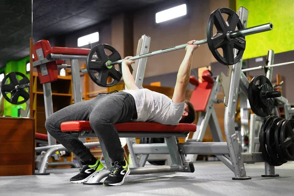 Jongeman doet Bench Press Workout in Gym — Stockfoto