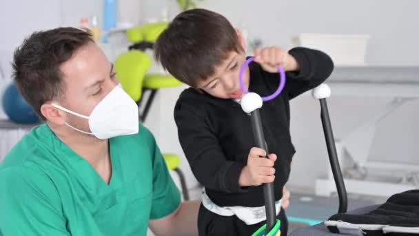 Child with cerebral palsy on physiotherapy in a children therapy center. Boy with disability has therapy by doing exercises with physiotherapists in rehabitation centre. — 图库视频影像