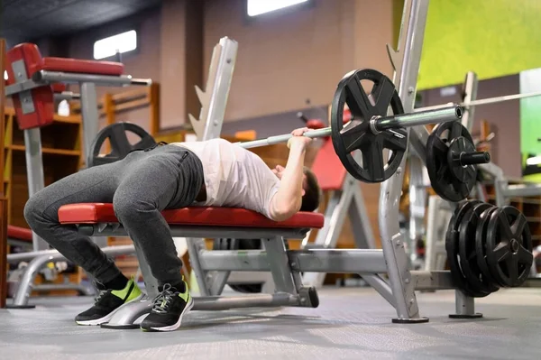 Jongeman doet Bench Press Workout in Gym — Stockfoto