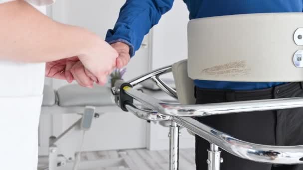 閉じる,女性看護師,患者の手を取ります,病院で車椅子に障害者の患者をサポート,若い医師のケアヘルプ麻痺患者. — ストック動画