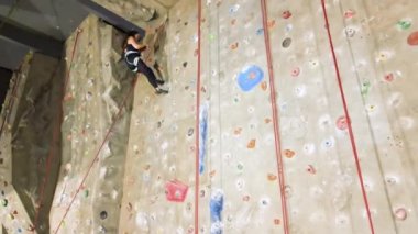 Genç, formda bir kadın, kapalı bir kaya duvarına tırmanıyor. Hava sineması görüntüleri 