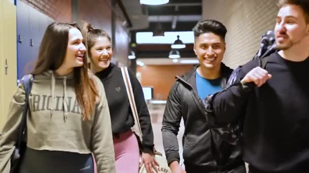 Estudantes do ensino médio caminham pelo corredor passando por armários em direção à classe. — Vídeo de Stock