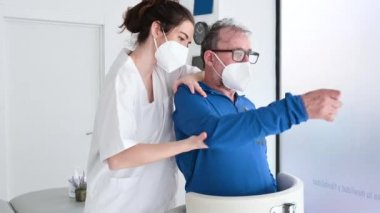 Amyotrofik Lateral Skleroz olan bir hastaya yardımcı olan fizyoterapist..