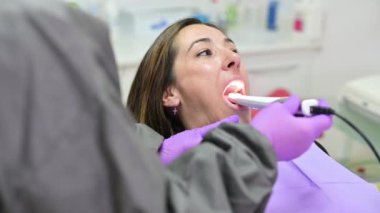 Doktor hastaların dişlerini intraoral kamerayla muayene ediyor.