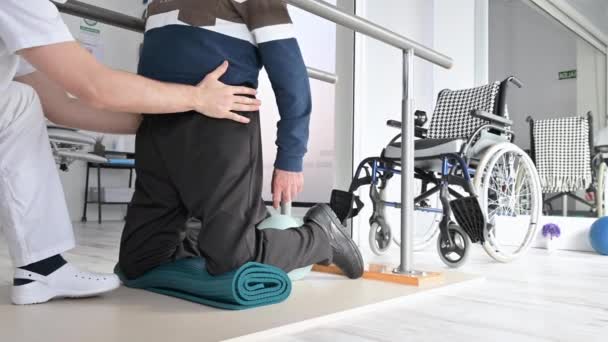 Физиотерапевт помогает инвалидному креслу в реабилитационном центре. — стоковое видео
