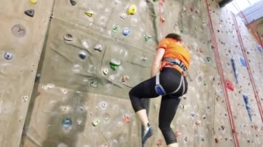 Genç bayan sporcu spor salonundaki tırmanma duvarından uzaklaştırıldı.