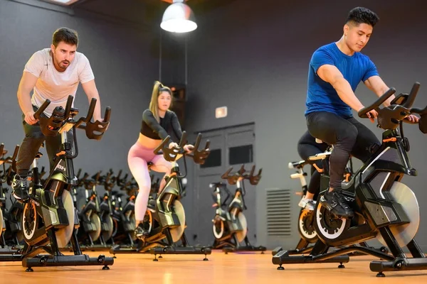 Groepsfietsen op een moderne fitnessfiets tijdens groepsles in de fitnessruimte — Stockfoto