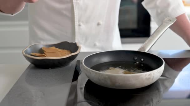 Närbild av manlig kock matlagning på stekpanna. — Stockvideo