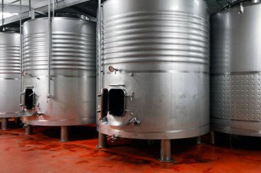 Şarap imalathanesinde fermantasyon için çelik variller.
