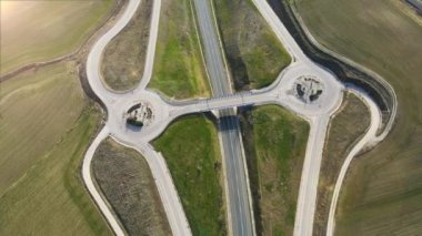 Kır yolu kavşağı üzerinde hava aracı görüntüsü. Kırsal alanda üstgeçitte trafik vardı.
