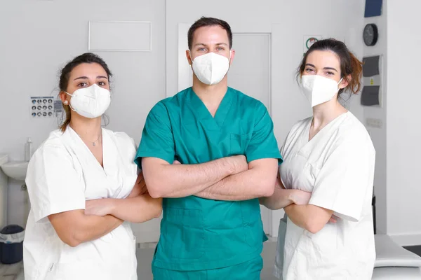 Diverse team van professionals in de gezondheidszorg dragen beschermende gezichtsmasker, werken in een fysieke revalidatie kliniek tijdens coronavirus pandemie. Rechtenvrije Stockafbeeldingen