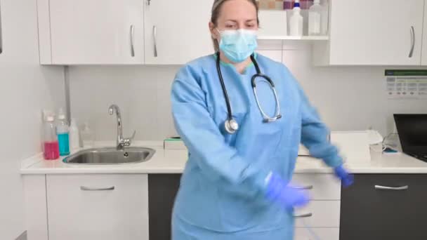 Positieve vrouwelijke arts dansen flos dans in het ziekenhuis, vieren het einde van het coronavirus pandemie. — Stockvideo