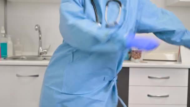 Pozytywna lekarka tańcząca nitkę dentystyczną w szpitalu, świętująca koniec pandemii koronawirusowej. — Wideo stockowe
