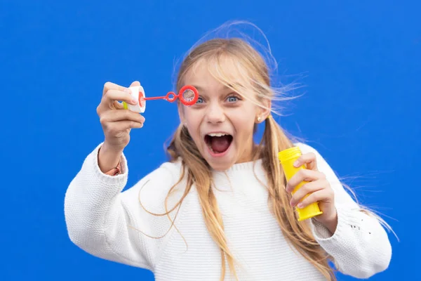 Menina engraçada soprando bolhas de sabão — Fotografia de Stock