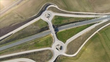 Kır yolu kavşağı üzerinde hava aracı görüntüsü. Kırsal alanda üstgeçitte trafik vardı.