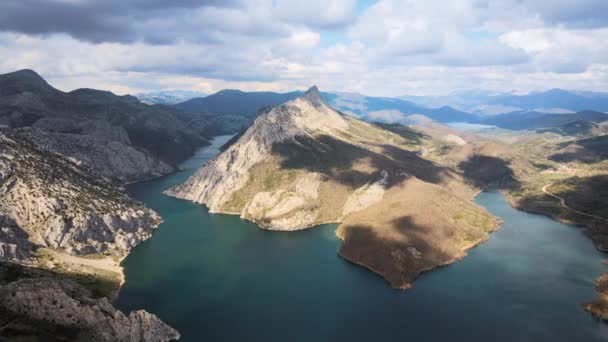 Vista aérea de un hermoso paisaje de lago de montaña. Agua esmeralda rodeada de montañas y nubes que pasan. — Vídeos de Stock