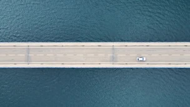 Вид с воздуха на мост с автомобилями над озером или морем. — стоковое видео