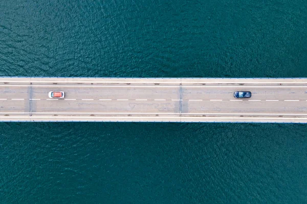 Вид с воздуха на мост с автомобилями над озером или морем. — стоковое фото