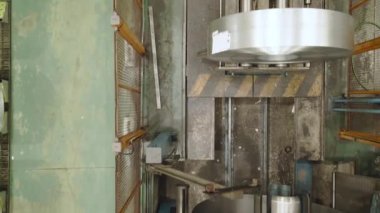 Bir operatörün vinç kıskacıyla çelik bobini kaldırışının havadan görüntüsü. Metal endüstrisi konsepti.