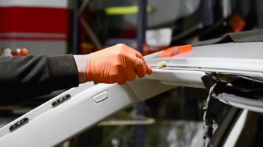 Otomobil tamircisinin otomobil tamirhanesindeki arabanın ön camını kapatırken.... 